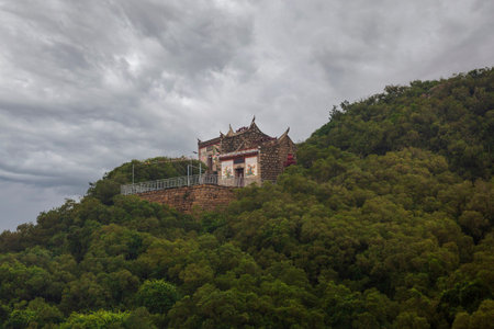 Pagoda at the top of a mountain with dramatic sky.の写真素材
