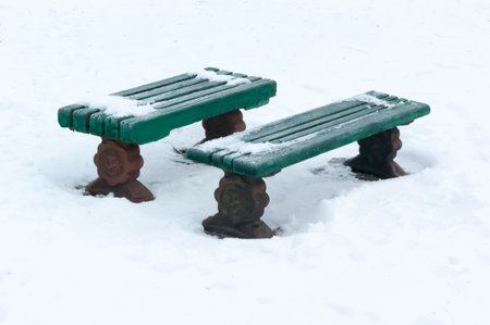 Two benches on the snow in the winter park