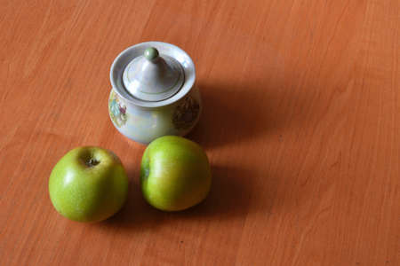 Green, ripe apples and porcelain sugar bowlの写真素材