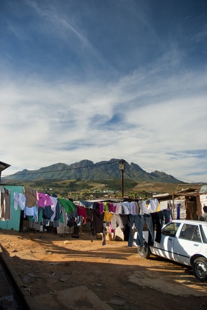 Various clothing lines with clothes hanging out to dry in front of shacks in a township in South Africa, with the mountains in the backgroundのeditorial素材