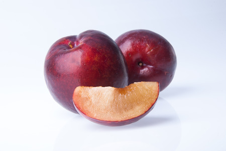 Ripe plum fruit on the white backgroundの写真素材