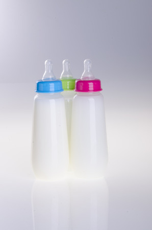 Baby bottles with milk on the white backgroundの写真素材