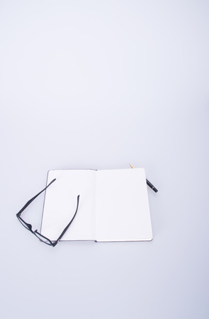 notebook with glasses and pen on the blackgroundの写真素材