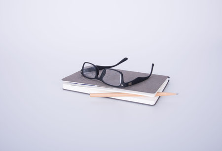 notebook with glasses and pen on the blackground