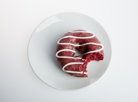 Donut with missing bite on a grey backgroundの写真素材