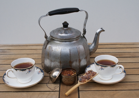 Tea for two prepared in an aluminum aluminum kettle with english tea cups as closeupの写真素材