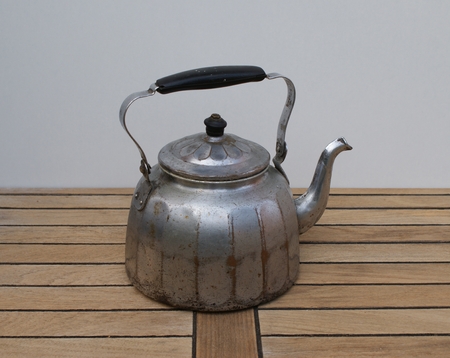 Closeup of an old aluminum water kettle with wooden handleの写真素材