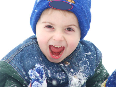 A young boy, in winter gear, has a surprised expression on his face.の写真素材