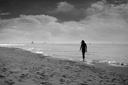 Woman Walks Along Lake Shore Near Saint Joseph Michiganの写真素材