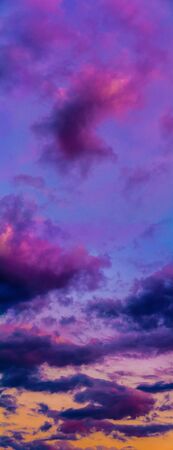 Panoramic view of the violet sky vertical during the blue hour after sunset with pink cloudsの写真素材