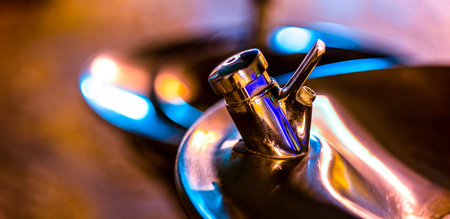 Macro faucet with shallow depth of light, illuminated by colorful street lightの写真素材