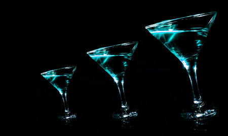 Panoramic view of turquoise drinks in a martini glass on a black backgroundの写真素材