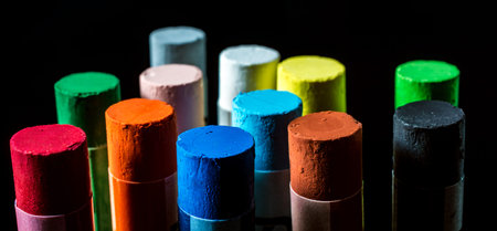 Panoramic view of colorful colored chalk macro on a black background