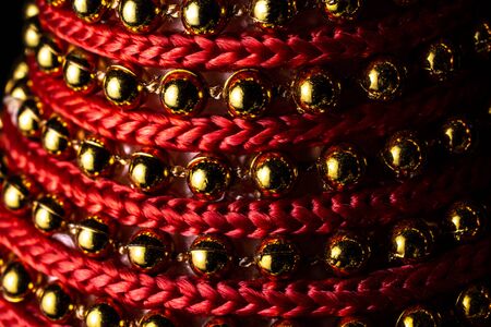 Golden shiny balls and red strings arranged in an attractive macro patternの写真素材