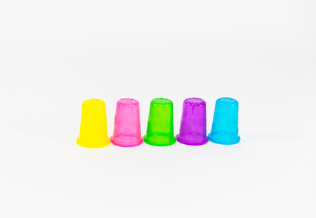 Colorful plastic cups of lemonade on a white background. utensils for a picnic and travelの写真素材