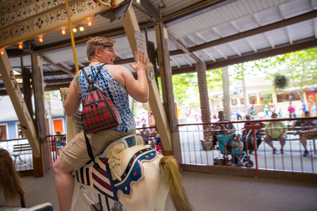 Elysburg, PA June 24 2018: People playing the Pony rides on a merry-go-round carousel.のeditorial素材