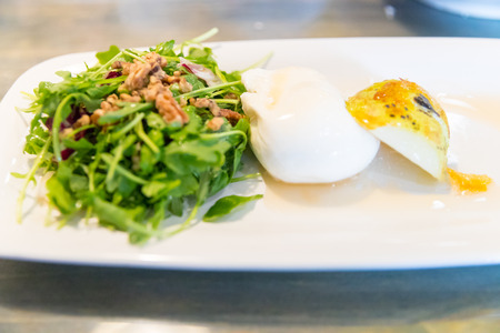 Classic salad with pear, arugula or rocket leaves, shaved parmesan, and walnuts. Drizzled with olive oil. lemon vinegar, burrata, spiced, macadamia.の写真素材