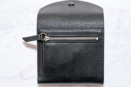 Top view of black genuine leather wallet with banknotes and credit card inside isolated on white...