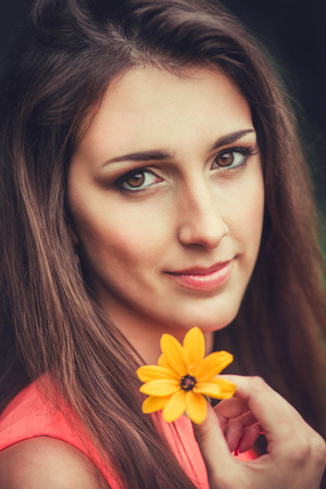 Happy beautiful young woman in spring blossom park. Pretty Girl with Spring Flowers. Fashion Model Outdoorsの写真素材