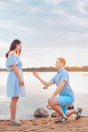 Marriage proposal on sunset . young man makes a proposal of betrothal to his girlfriendの写真素材