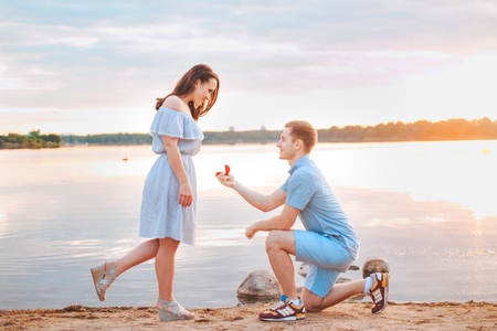 Marriage proposal on sunset . young man makes a proposal of betrothal to his girlfriendの写真素材