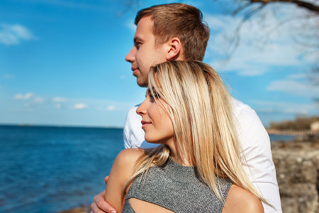 Happy couple on sea background. Happy young couple laughing and hugging on the beachの写真素材