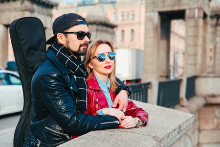 Beautiful couple in sunglasses on the bridge in city . Rock style . Couple in loveの写真素材