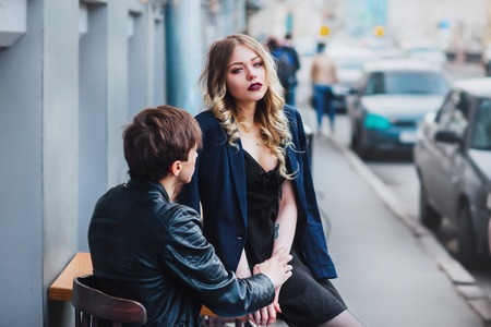 stylish hipster couple in cafe outdoor. portrait of sexy couple in city . Couple talking in cafeの写真素材