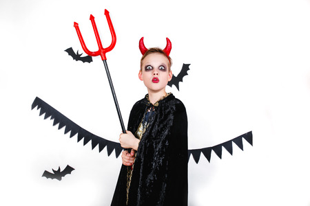 holiday halloween. funny child in carnival costumes devil on a white backgroundの写真素材