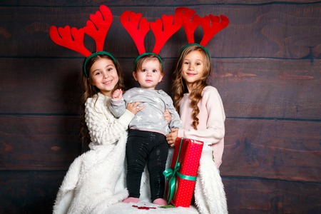 Smiling funny pretty sisters in deer horns in studio.Merry christmas and happy new year .の写真素材