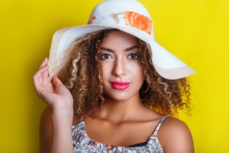 Beauty portrait of young african american girl with afro hairstyle in summer hat. Vacation conceptの写真素材