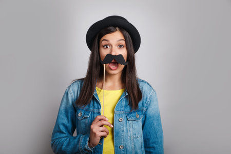 Celebration and party. Having fun. pretty woman in hat is laughing. Girl wearing fake mustaches.