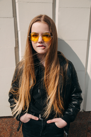 beautiful fashionable kid girl with long hair in yellow sunglasses in city, Street fashion kid,の写真素材