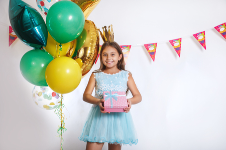 Portrait of a happy cute little kid holding gift box and looking at cameraの写真素材