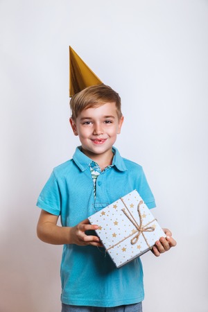 Portrait of a happy cute little kid holding gift box and looking at cameraの写真素材