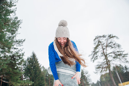 Happy winter travel couple. Man giving woman piggyback ride on winter vacation in snowy forest.