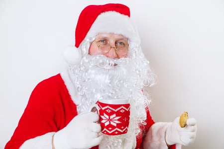 Close up of happy Santa Claus with glass of milk and cookie. Christmas timeの写真素材