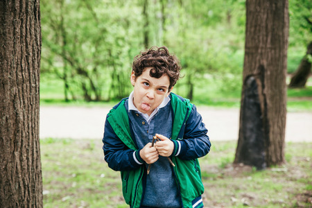 Funny boy having fun. The child makes faces outdoorsの写真素材