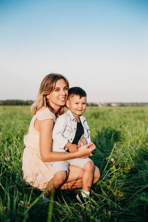 Smiling mother and baby sitting on meadowの写真素材