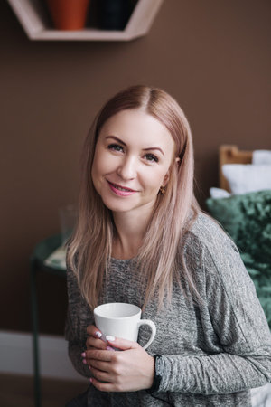 Portrait of happy beautiful blond with mug in hands