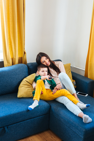Young family watching TV together at homeの写真素材