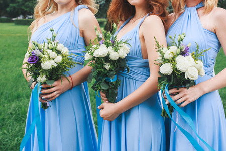 Wedding ceremony flower in hands of bridesmaidsの写真素材