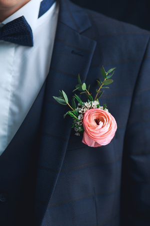 Close-up of pink ranunculus boutonniere on stylish groomの写真素材