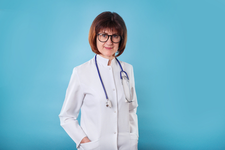 Doctor in eyeglasses with stethoscope on blue backgroundの写真素材