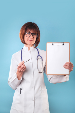 Doctor with blank sign on clipboard on blue backgroundの写真素材