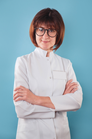 Portrait of doctor smiling on blue backgroundの写真素材