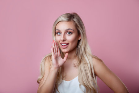 Talkative beautiful woman with blonde hair saying secret hot braking news and looking at camera on...