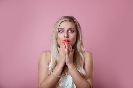 Woman happy and surprised shouts holds cheeks by handの写真素材