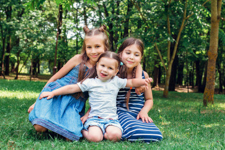 Three cute little sisters playing in park in summer dayの写真素材