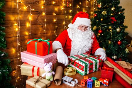 Merry Christmas and Happy Holidays. Santa Clause is preparing gifts for children at home.の写真素材